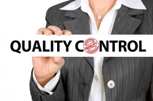 The close up of a woman holding a sign that says quality control.