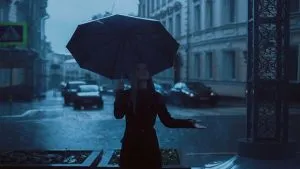 A girl on the street holding an umbrella