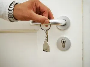 Hand holding a door knob and a set of keys.