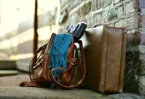 A suitcase and a bag leaning against a wall.