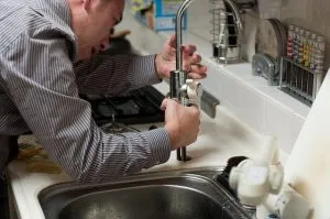 A repairman fixing a sink.