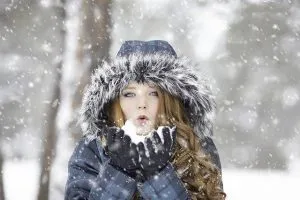 A redhead girl standing in the snow.