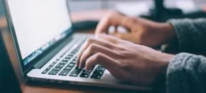 a man typing on a laptop