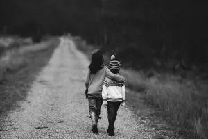 Two kids walking while embraced