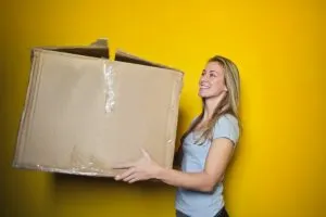 A woman carrying a moving box