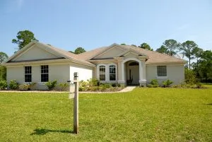 a family home with a large backyard and a sale sign in front of it