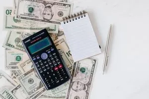 Picture of dollars and a calculator. Budgeting for a local move is important if you want to save some money