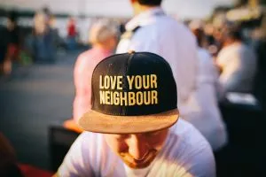 A man with a "love your neighbor" hat