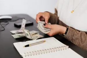 Picture of a woman counting money. Prepare your budget for moving house this fall