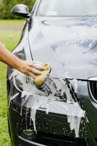 Picture of a woman cleaning a car. Visit your local carwash before shipping your car to Hong Kong