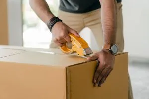 man closing a moving box