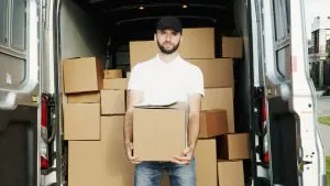 male holding a moving box