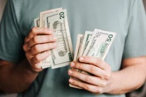 a person counting dollar bills