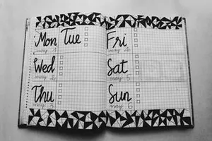 White and black weekly planer on gray surface