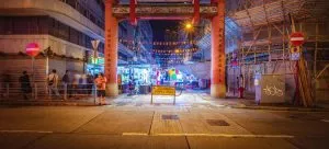 A traditional Chinese gate in the center of a lively city during night