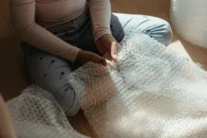 woman hold plastic wrap - pack porcelain for a move