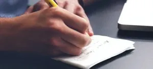 A guy writing on a paper