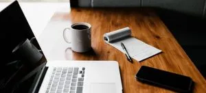 A desk with a laptop and a notebook