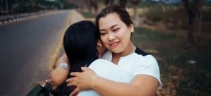 Women hugging each other.