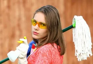 a woman holding cleaning supplies