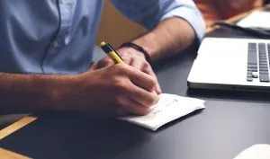 a man writing something down - work from home in a studio apartment
