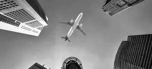 plane flying over the buildings