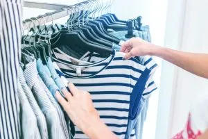 Person looking at pieces of clothing you should buy for your first year in Hong Kong
