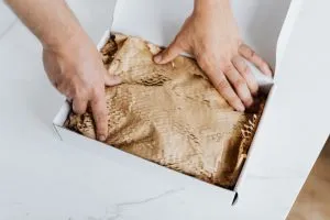 Person packing something in moving box - You need to specifyany additional service you need when applying for a moving estimate