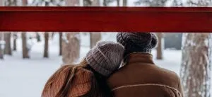 couple dressed in winter clothes sitting at the window