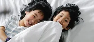 two children lying on the bed