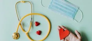 Medical stethoscope and mask composed with red foiled chocolate hearts