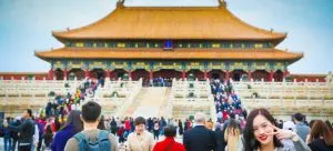 a Chinese temple and a woman standing in front of it