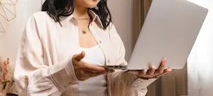 A confused woman looking at a laptop