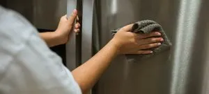 a woman cleaning a fridge