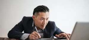 Man looking at the laptop while looking for tips on how to tip movers in Hong Kong.