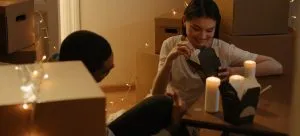 Boy in white dress shirt sitting beside woman in black long sleeve shirt.