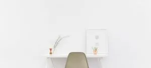 Beige and black chair in front of white desk.