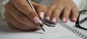 a woman writing a travel packing list for expats