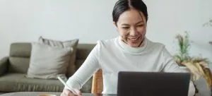 Young woman using a laptop to digitize some of her belongings