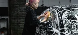 Woman cleaning a car.