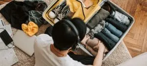 a man listening to music while packing clothes