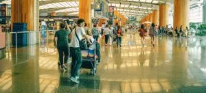 a person walking at the airport pushing his luggage