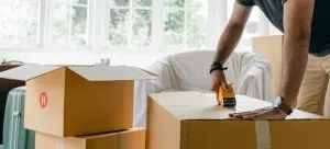A man packing box with duct tape