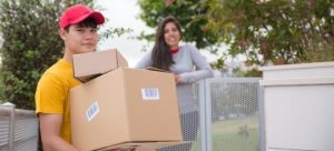 A man with a cap holding a box
