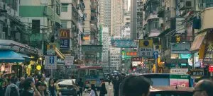 People On Road Between Buildings.