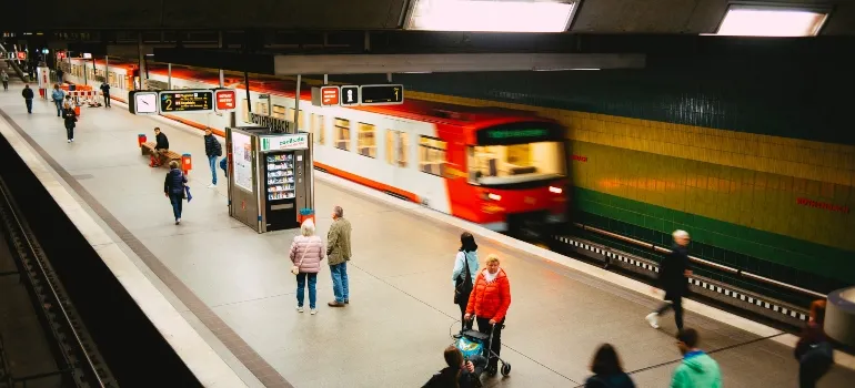 People walking on a train station next to a red train