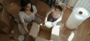 Woman and kid packing with bubble wrap