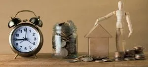 Clock, coins, wooden house, wooden statue of a man