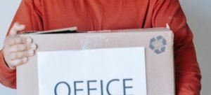 a man holding a box with office things