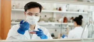 lab technician with mask and blue gloves planning to relocate a healthcare institution in Hong Kong